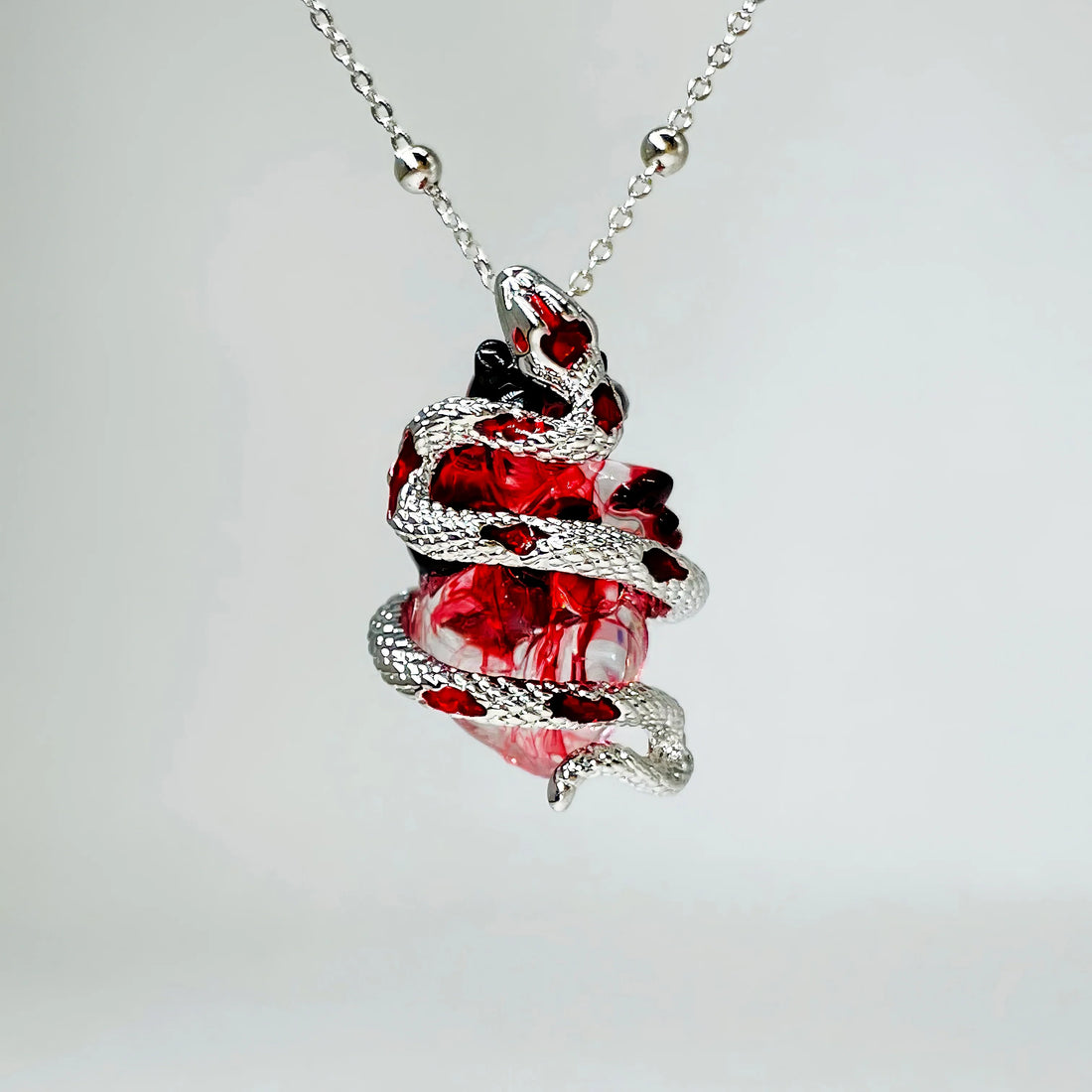 Unleash Your Bold Style with the Silver Snake Wrapped Heart Pendant